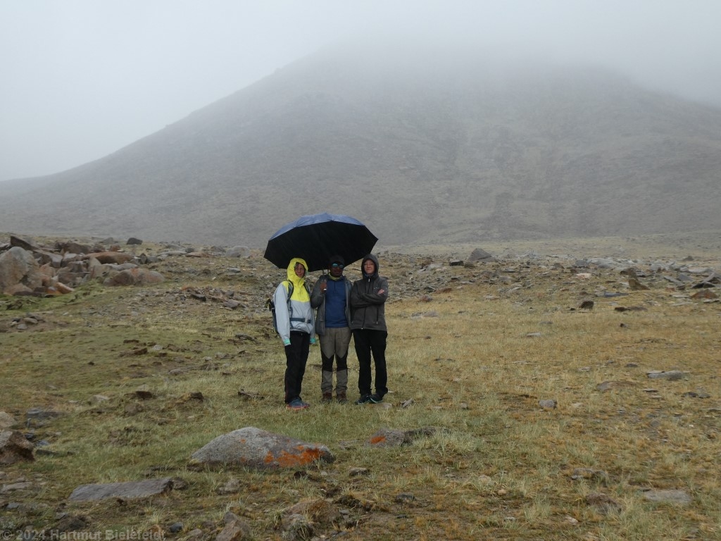 Ein Regenschirm für vier, die auf die Mannschaft warten
